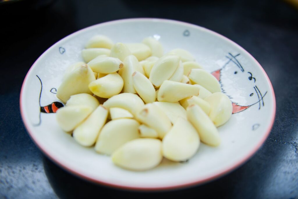 Plate of peeled fresh garlic cloves ready to be covered in honey for fermenting