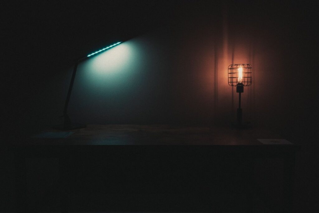 Lamps giving off cool and warm light on a table in a dark room